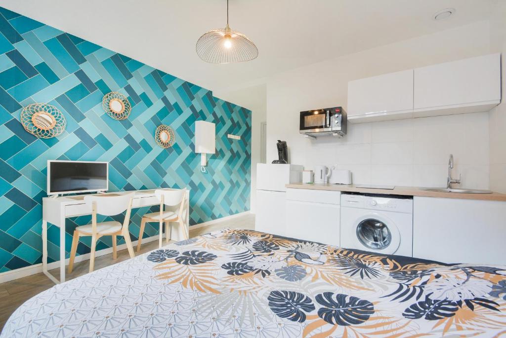 une chambre avec un lit et un bureau et une cuisine dans l'établissement Studios Nancy GARE - STANISLAS, à Nancy