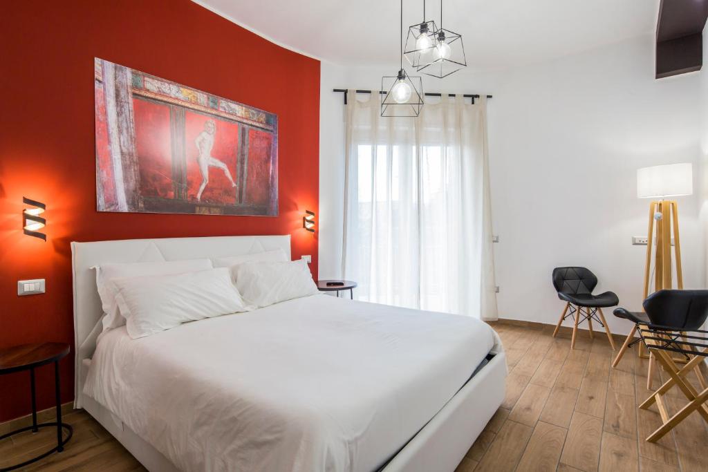 una camera con letto bianco e pareti arancioni di Pompei Centrum a Pompei