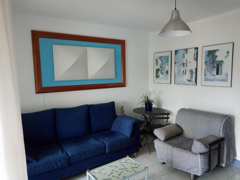 a living room with a blue couch and a chair at Luxury apartment in Port Grimaud in Grimaud
