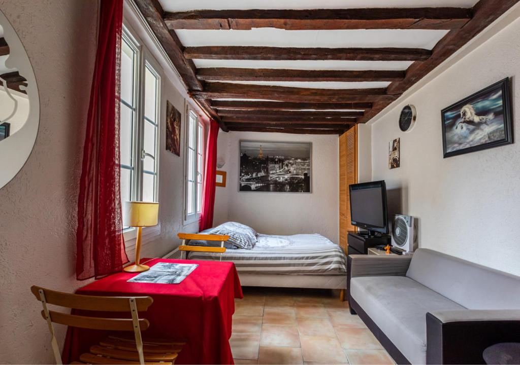 Appartement Mouffetard في باريس: غرفة بسرير وطاولة وأريكة