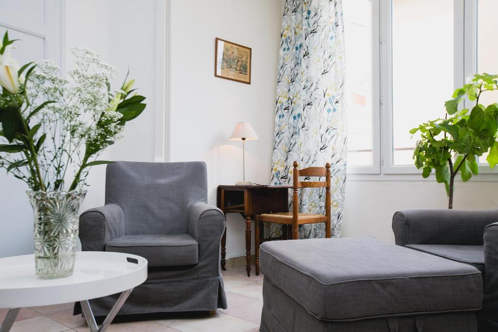 a living room with two chairs and a table at Regina's Banyuls - Spatious apartment next to the beach in Banyuls-sur-Mer