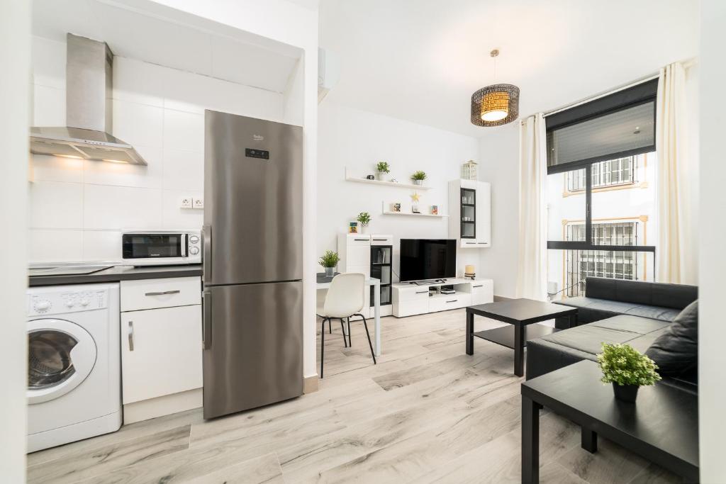 een keuken en een woonkamer met een roestvrijstalen koelkast bij Málaga Suite Picasso in Málaga