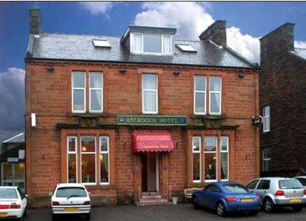 un edificio de ladrillo con coches estacionados frente a él en Aberdour Guest House en Dumfries