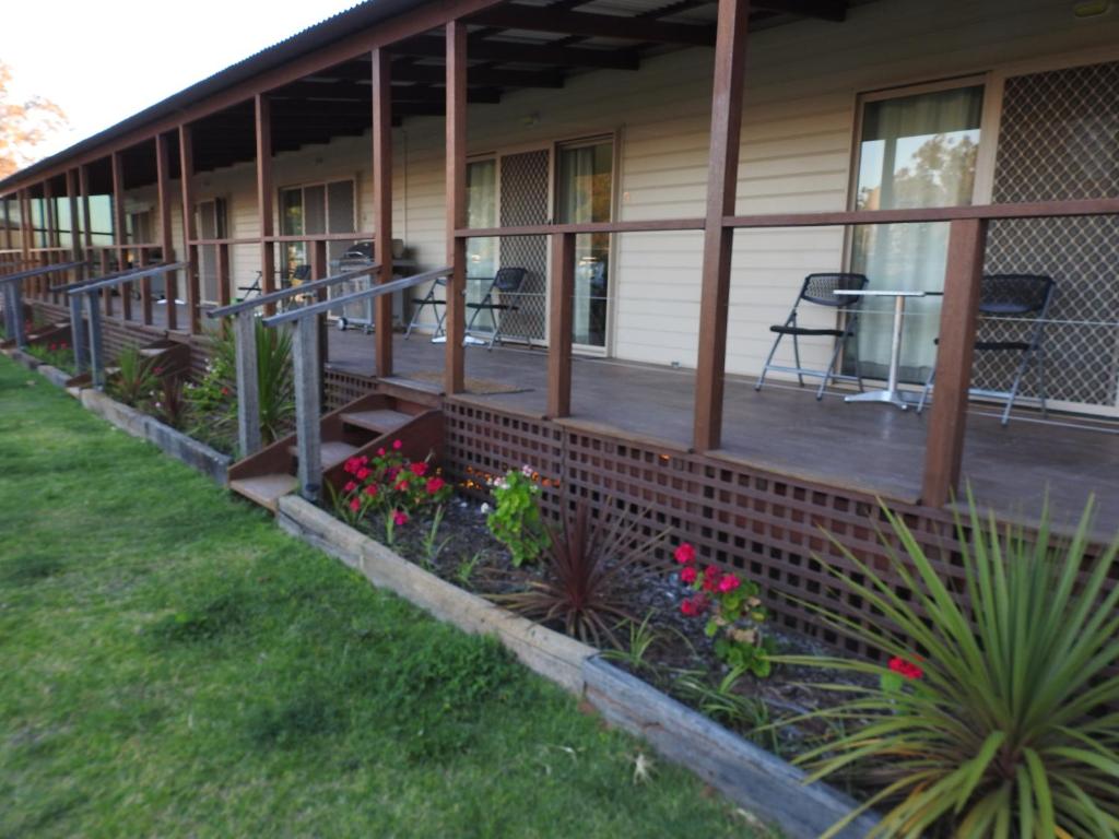 a front porch of a house with flowers and plants at Warrawong on the Darling Wilcannia Holiday Park in Wilcannia