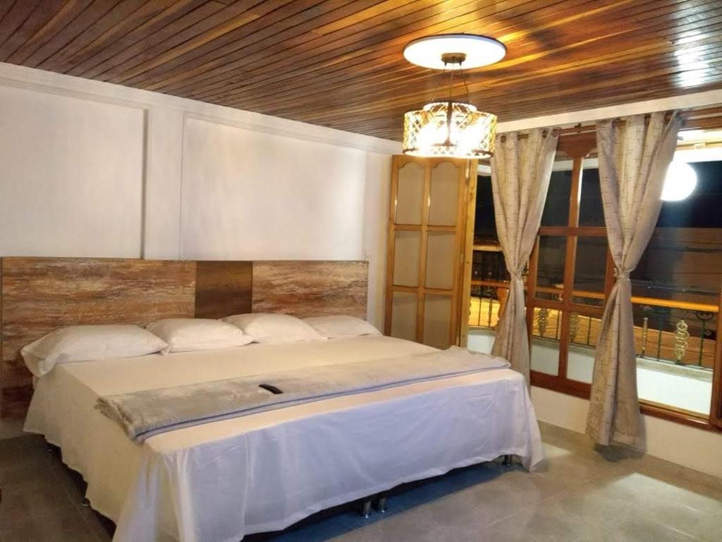 a bedroom with a large bed with a wooden ceiling at CIELITO LINDO in Santa Rosa de Cabal