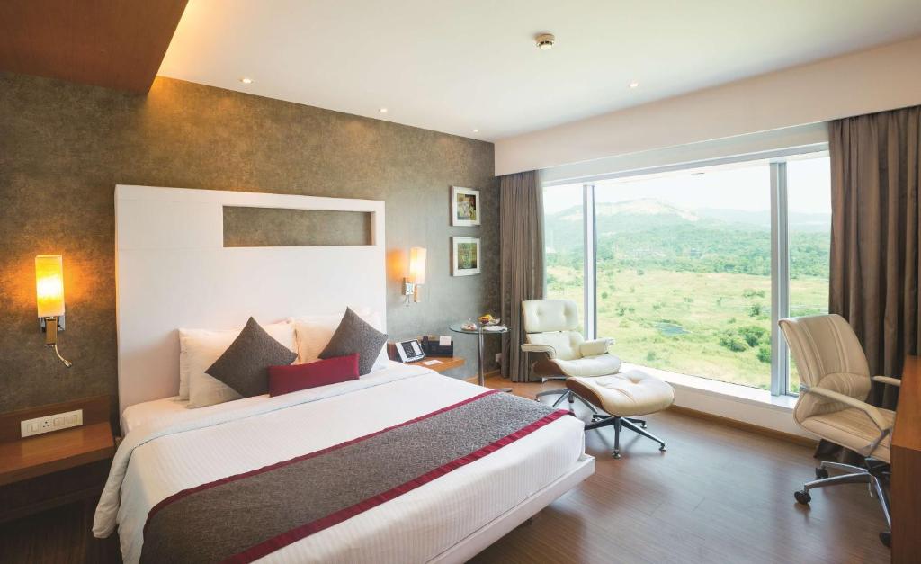 Habitación de hotel con cama y ventana grande en Country Inn & Suites By Radisson Navi Mumbai, en Navi Mumbai