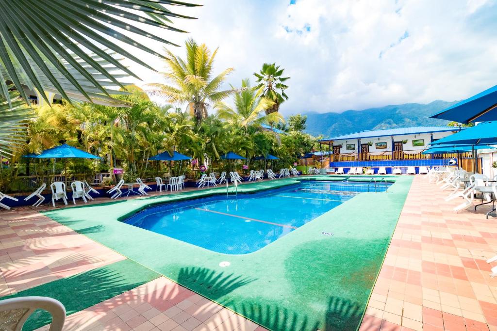 a pool at a resort with chairs and umbrellas at Ayenda 1132 Copiclub in Ibagué