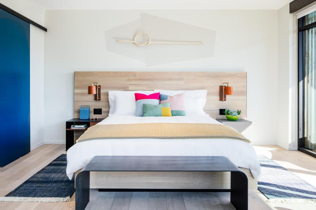 a bedroom with a large bed with colorful pillows at Hotel San Luis Obispo in San Luis Obispo