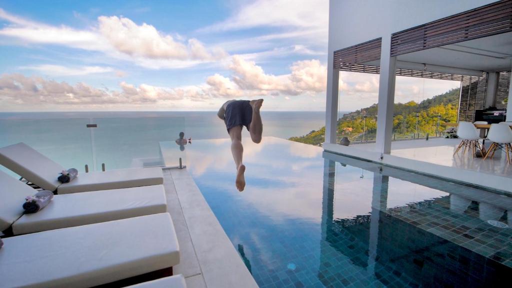 a person jumping into a swimming pool in a house at 180 Samui in Koh Samui