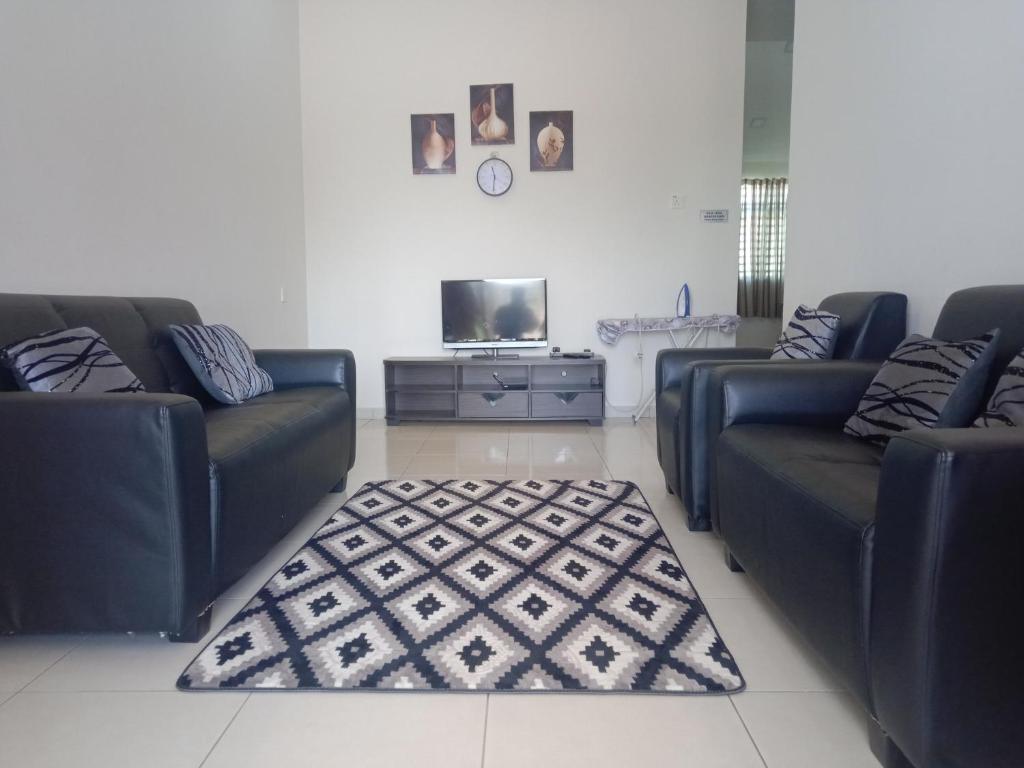 a living room with two couches and a television at Hazz Homestay Alor Setar in Alor Setar