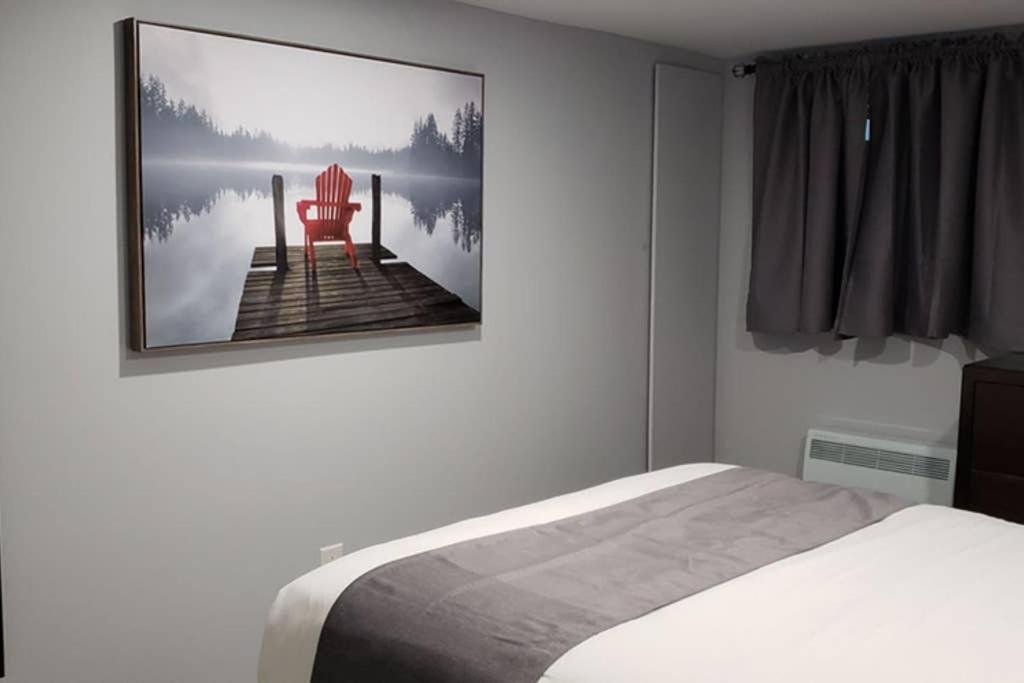 a bedroom with a bed and a chair on a pier at 1-Bedroom Mi Casita by Amazing Property Rentals in Gatineau