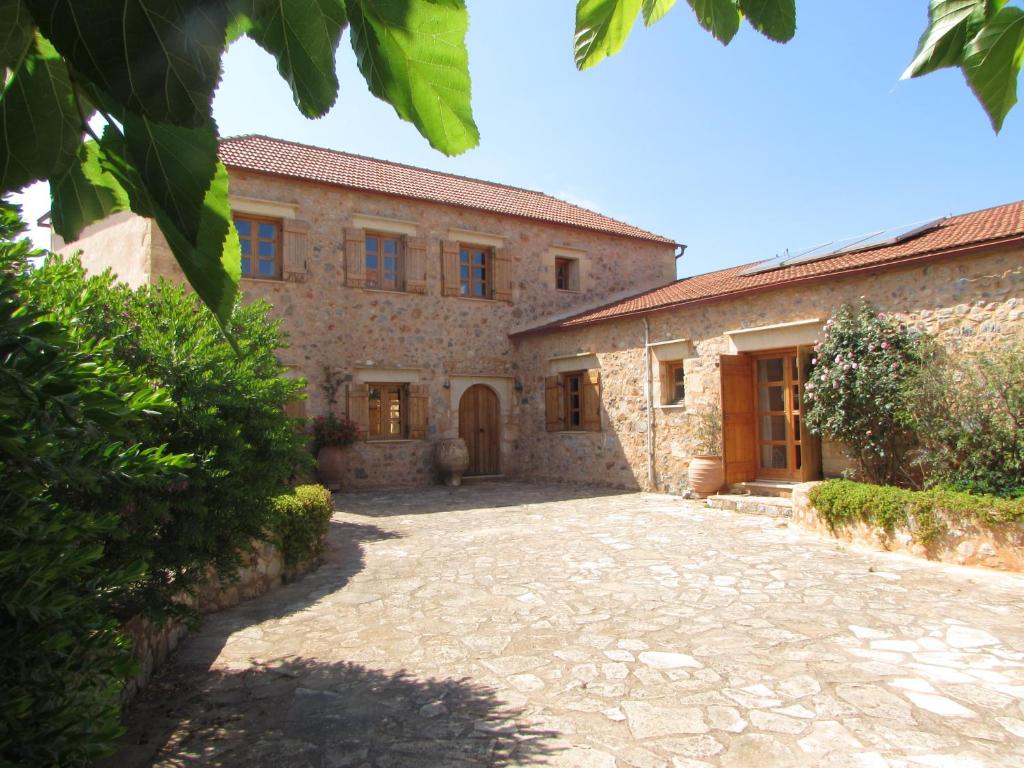 una vista exterior de una casa de piedra con entrada en Villa Magdalena, en Epáno Kefalás