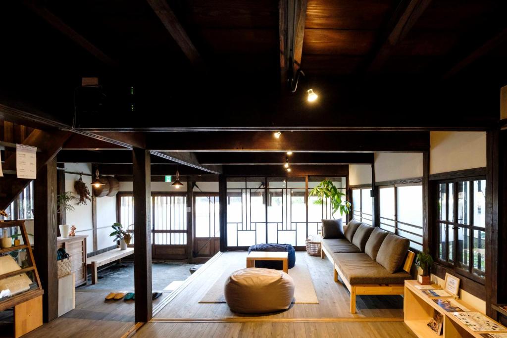 uma sala de estar com um sofá e uma mesa em Guest House Maru em Kashima