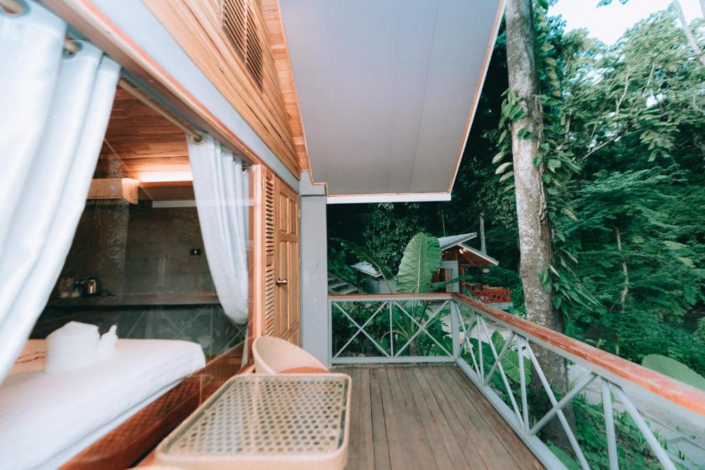 an outdoor balcony with a bed and a tree at Luxury Camp@Green Jungle Park in Luang Prabang