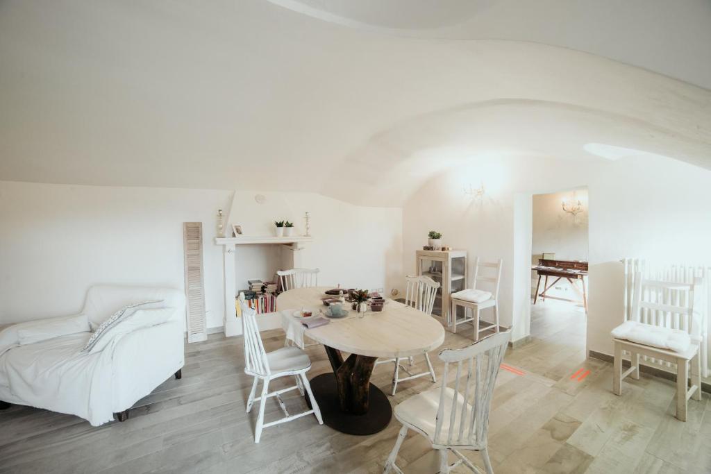 Biały salon ze stołem i krzesłami w obiekcie Guest House Al Devesio w mieście Rifreddo