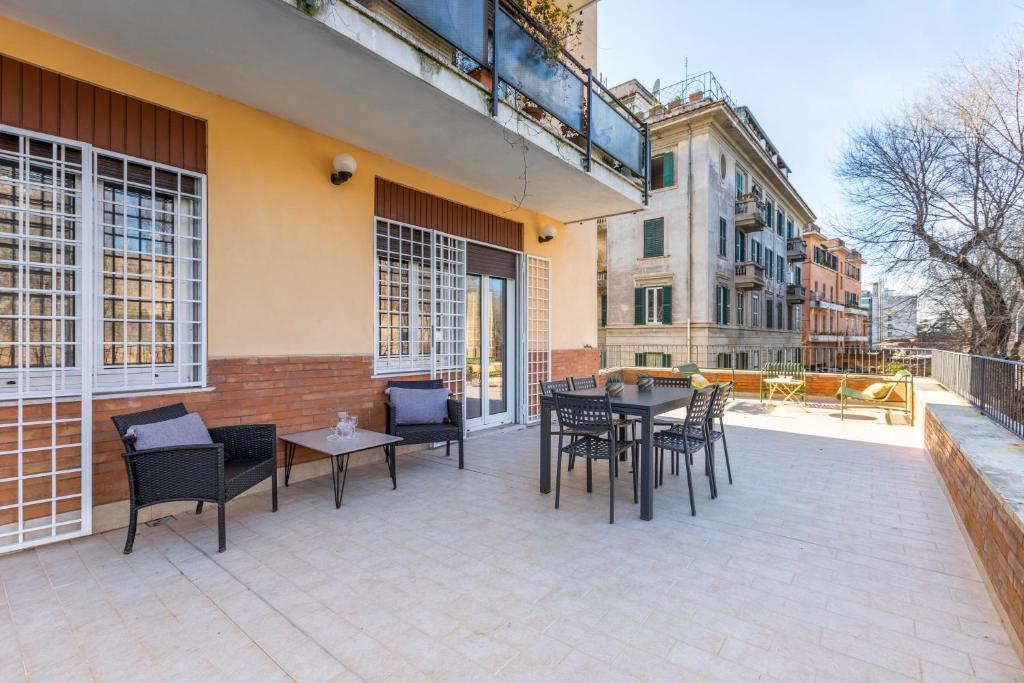 taras ze stołem i krzesłami na budynku w obiekcie ROMAC San Saba 5-Bedroom and Terrace near Ostiense w Rzymie
