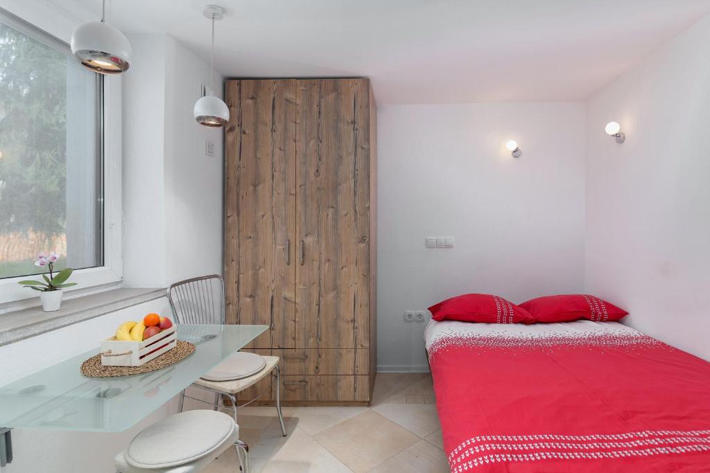 una camera con letto rosso e porta in legno di Studio Sergio a Bled