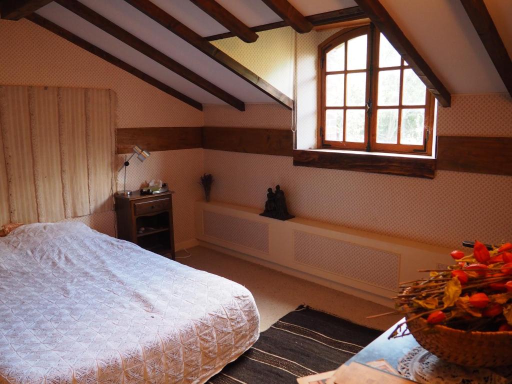 a bedroom with a bed and a window and a table at La grange in Alluyes