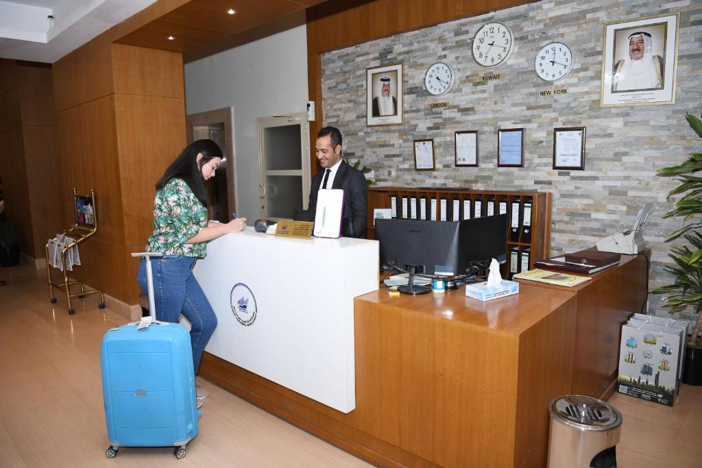 Um homem e uma mulher ao balcão. em Continental Inn Hotel Al Farwaniya em Kuwait