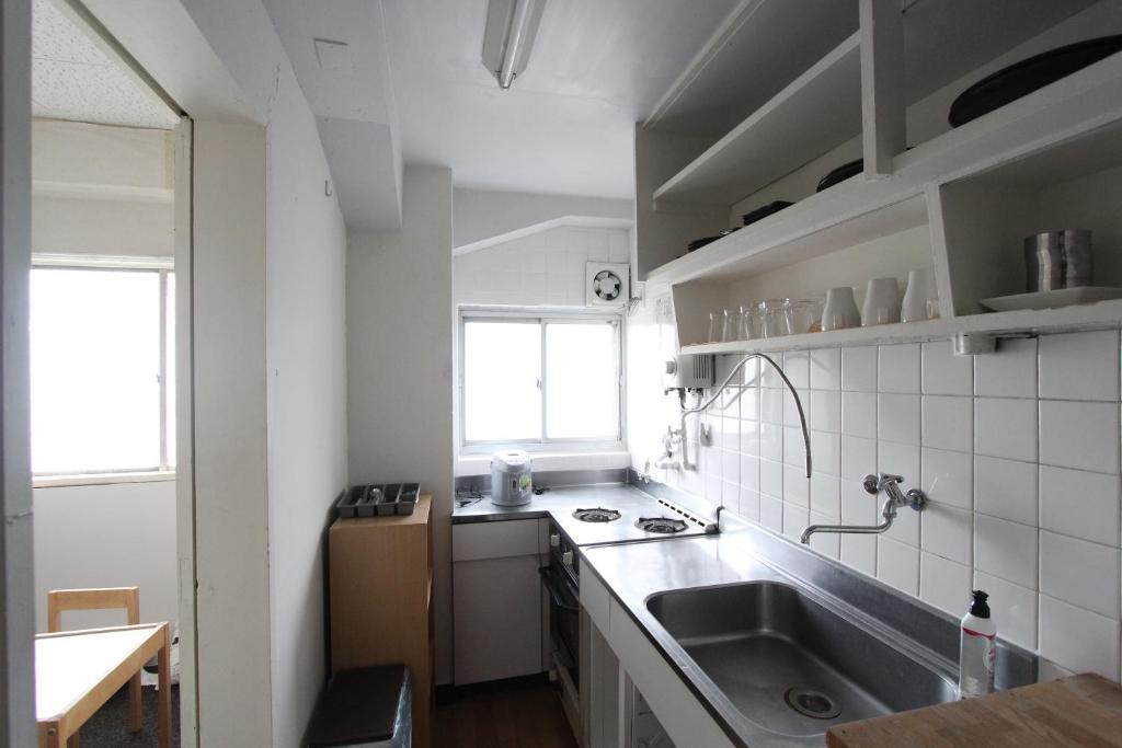 a small kitchen with a sink and a window at Sea View Court Kobe in Kobe