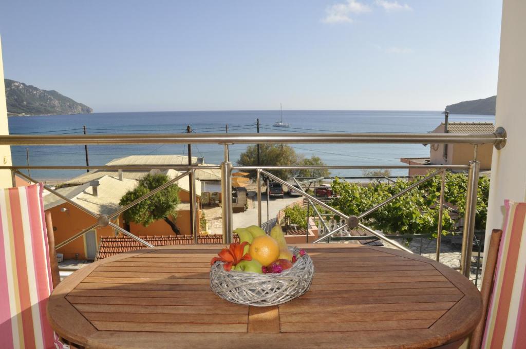a bowl of fruit on a table on a balcony at Corfu Studios Stavroula - San George Apartments in Agios Georgios Pagon