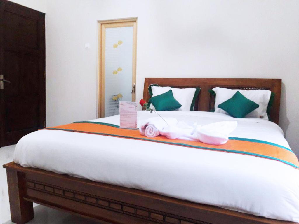 a bedroom with a bed with two dolls on it at Homestay Purbalingga Tengah Kota by Simply Homy in Purbolinggo