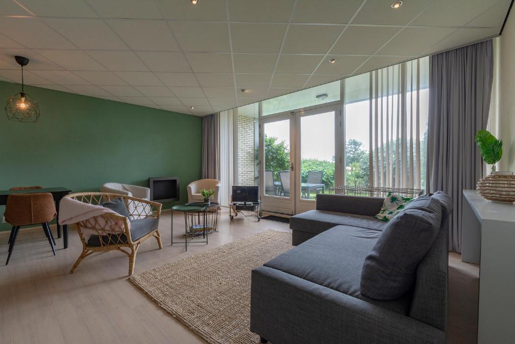 - un salon avec un canapé et une table dans l'établissement Strandslag 115 Beach Apartment, à Julianadorp
