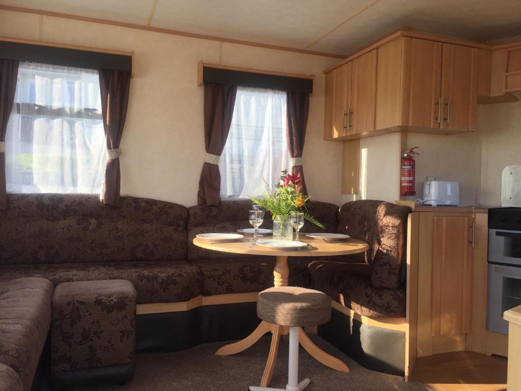 a small living room with a table and a couch at The 'Croyde' Caravan in Bideford