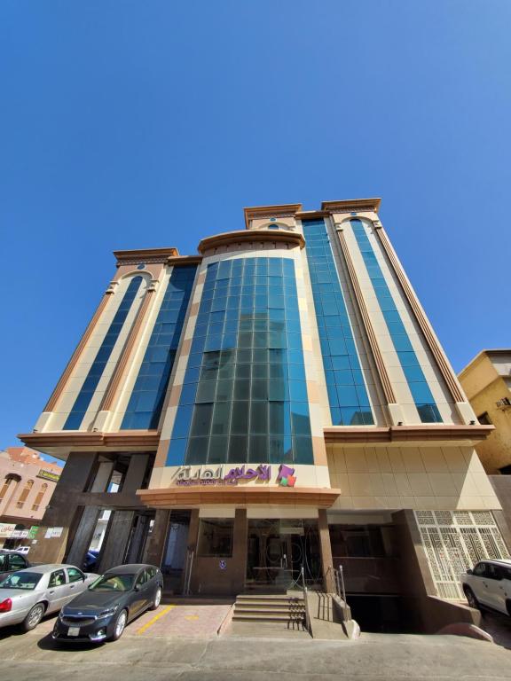 a tall building with cars parked in front of it at Quiet Dreams - Quraysh Branch in Jeddah