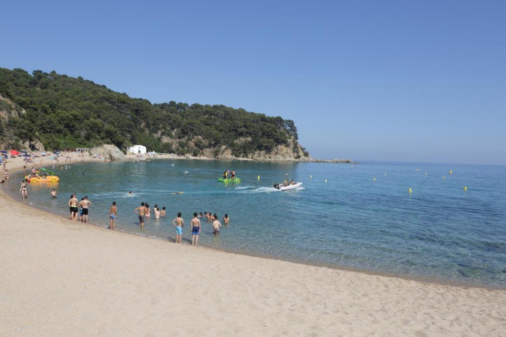 un gruppo di persone in acqua in spiaggia di Happy Camp mobile homes in Camping Sènia Cala Canyelles a Lloret de Mar