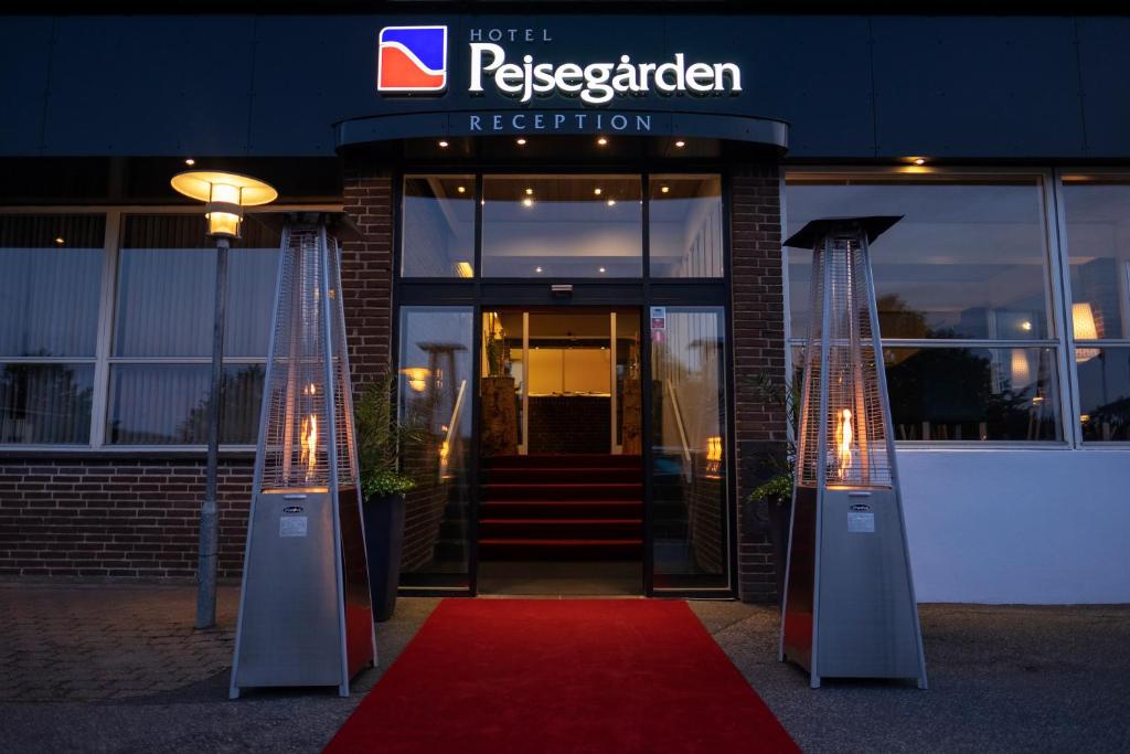 a red carpet in front of a building with a red rug at Hotel Pejsegaarden in Brædstrup