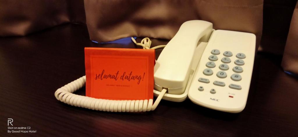 um telefone e um livro sobre uma mesa em Good Hope Hotel Kelana Jaya em Petaling Jaya