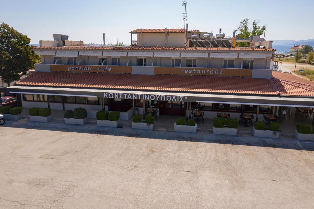 ein Gebäude mit einem Schild, das Kavanagh verbessert in der Unterkunft Pension Konstantinoupolis in Asprovalta