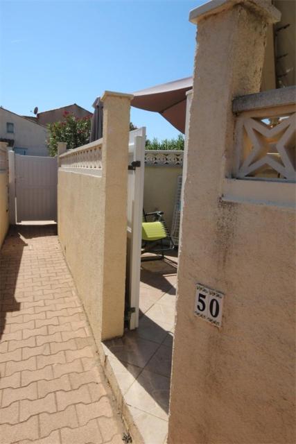 une maison avec un petit nombre sur son côté dans l'établissement villa 3 chambres 6 couchages, cuisine climatisée, petite terrasse, résidence sécurisée piscine commune 400m de la mer LRJP50, à Portiragnes