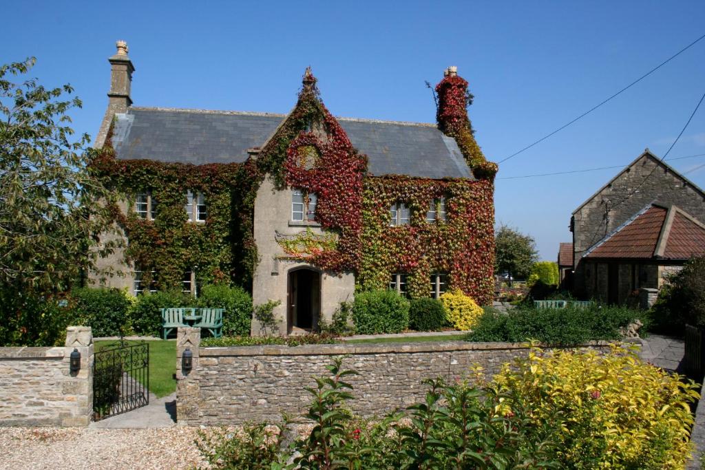 una vieja casa con hiedra creciendo en ella en Toghill House Farm, en Wick