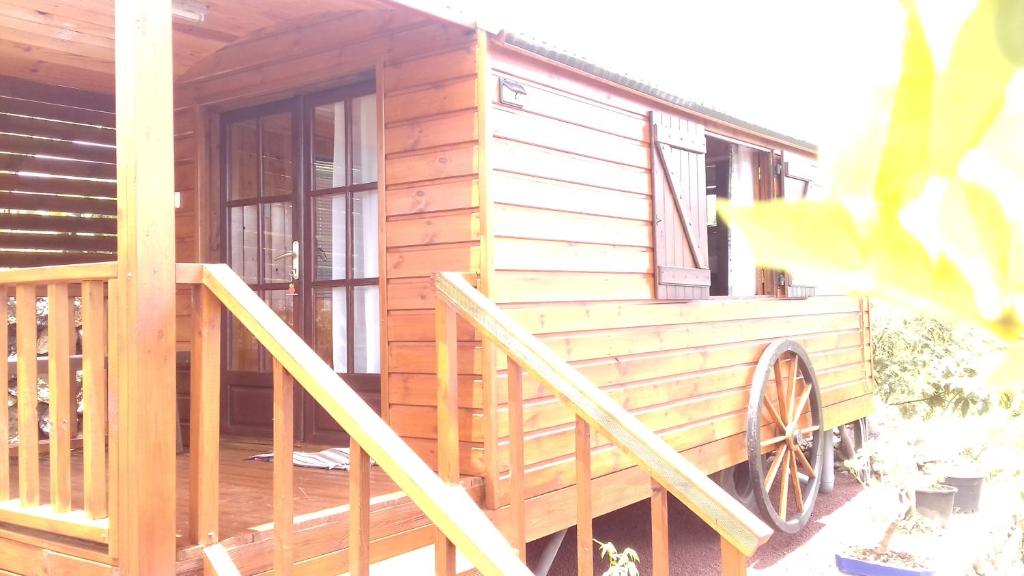 eine Blockhütte mit einer Veranda und einer Holzterrasse in der Unterkunft Ferme Lebon Papillon LA ROULOTTE in Le Tampon