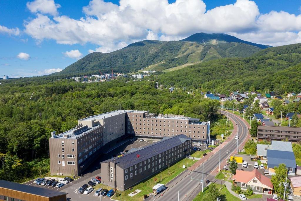 新雪谷的住宿－Midtown Niseko，城市的空中景观,背景是群山