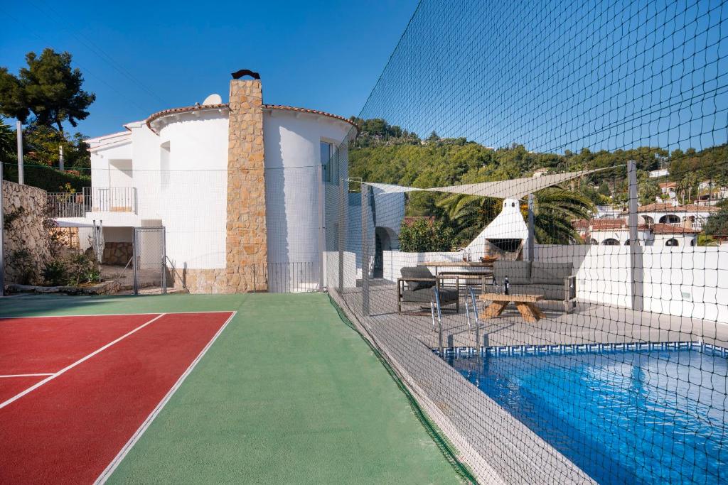 een huis met een zwembad en een hangmat naast een huis bij Sara 10 - free WIFI, chill-out, private pool, private tennis court - by Holiday Rentals Villamar in Benissa