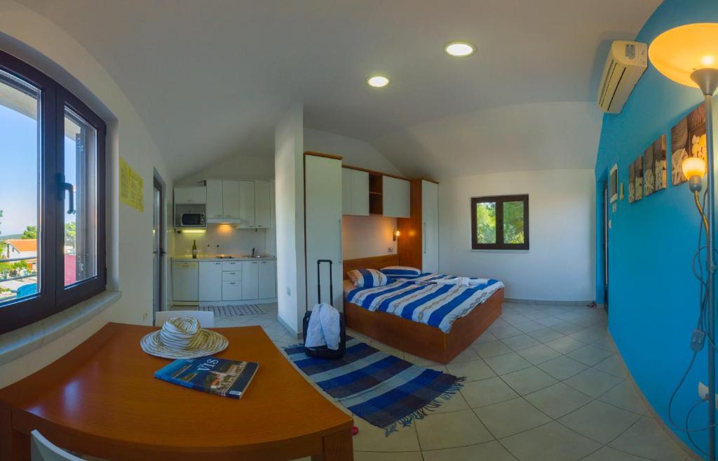 a bedroom with a bed and a table and a kitchen at VIScovery apartments in Vis
