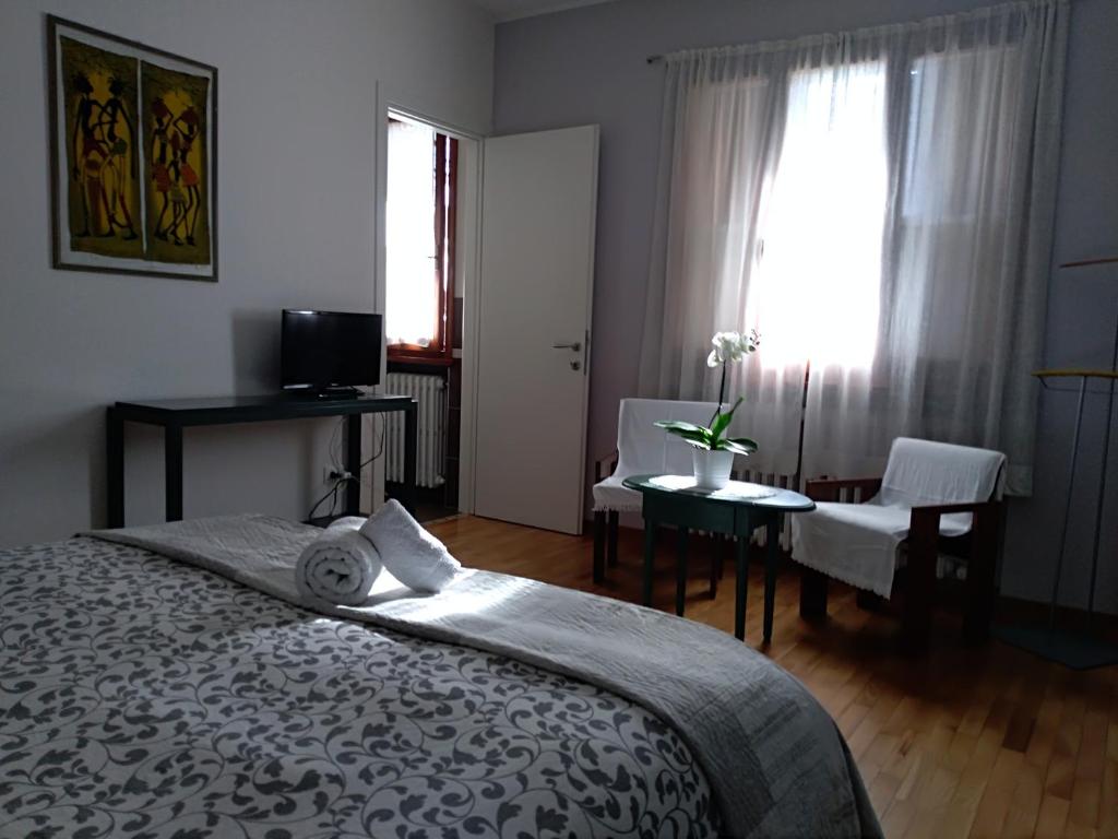 een slaapkamer met een bed en een tafel en stoelen bij Home Meditamondo in Fano