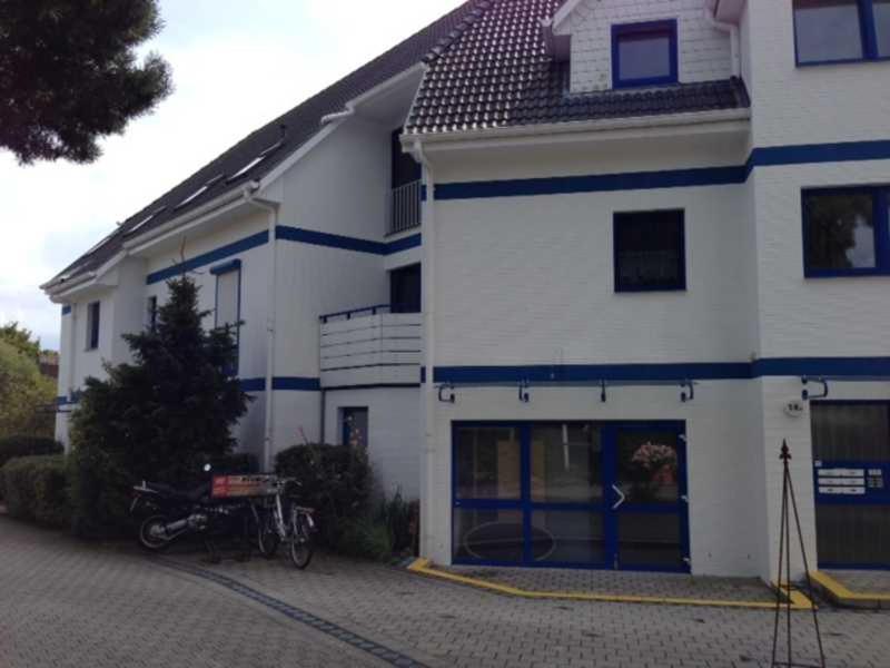 ein weißes Haus mit einem Motorrad davor geparkt in der Unterkunft Klosterstr.14 Wohnung 4 in Zingst