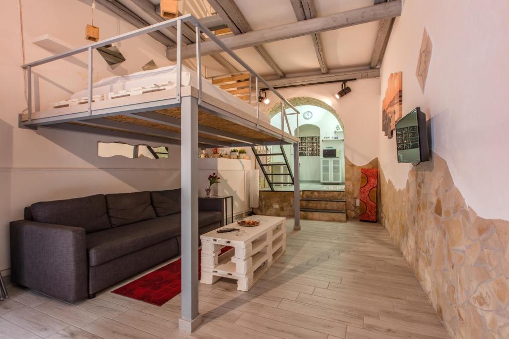 un soggiorno con letto a soppalco e divano di Casa Cerami a Catania