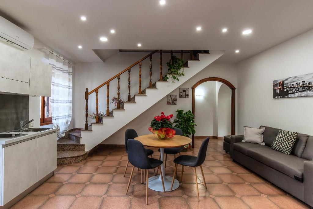 a kitchen and living room with a table and a couch at Plaza Rooms Ciampino in Ciampino