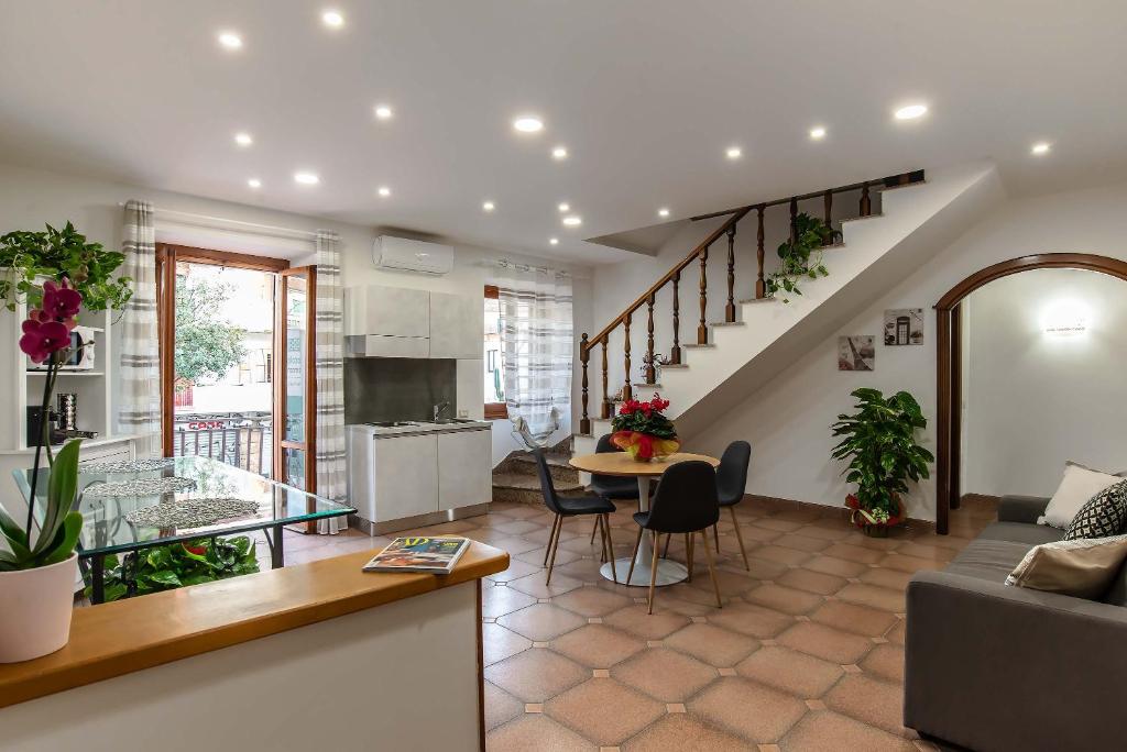 a kitchen and living room with a couch and a table at Plaza Rooms Ciampino in Ciampino