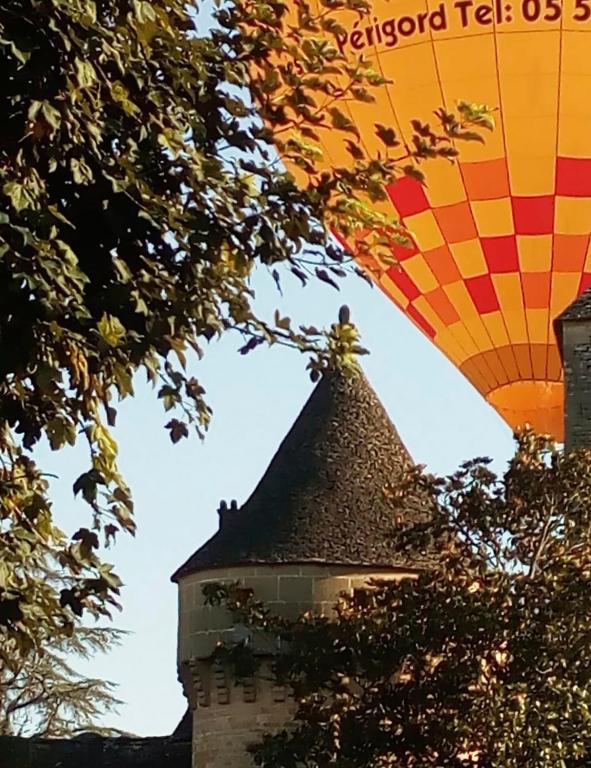 a hot air balloon is flying over a building at pipowagen Blagour midden in de natuur in Lachapelle-Auzac