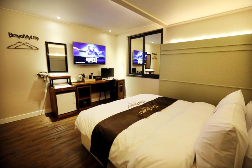 um quarto de hotel com uma cama e uma televisão em Hotel Two Heart em Daegu