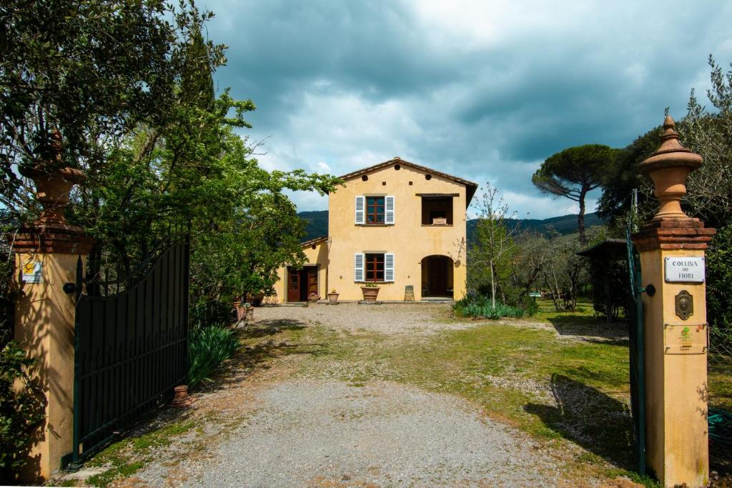 una casa con un cancello di fronte a un vialetto di Collina dei Fiori a Castiglion Fiorentino