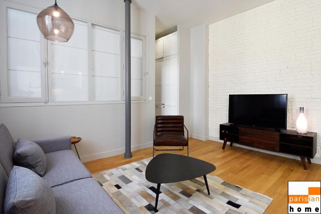 een woonkamer met een bank en een flatscreen-tv bij 202117 - Appartement 6 personnes à Paris in Parijs