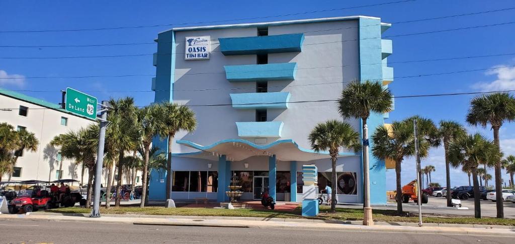 un edificio con palmeras delante en Fountain Beach Resort - Daytona Beach, en Daytona Beach