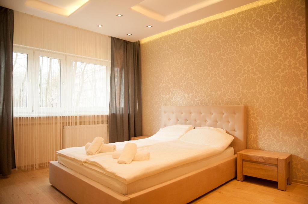 1 dormitorio con 1 cama blanca grande y ventana en Apartament Turoszowska en Lodz